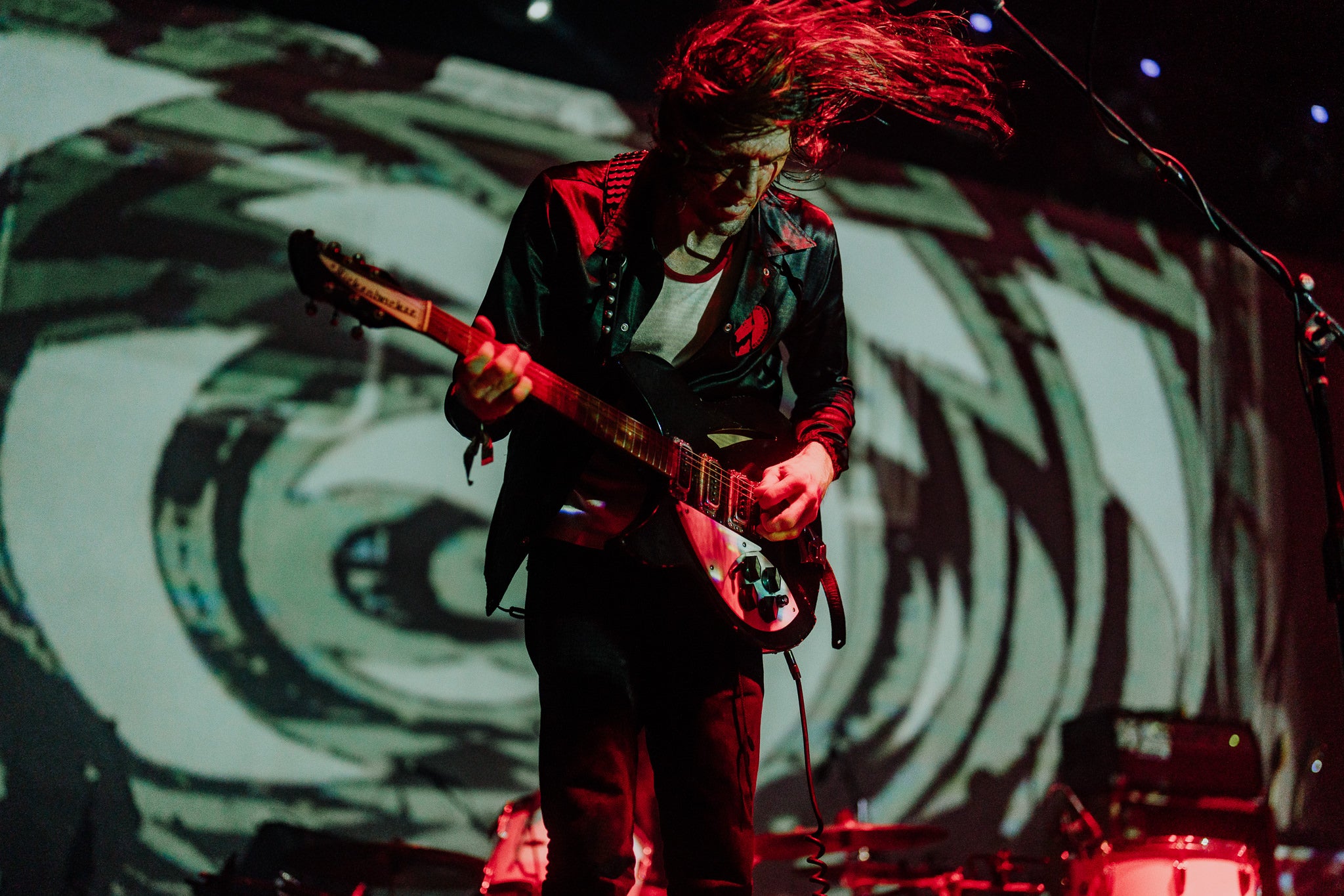 Live guitarist under red lights at a Levitation club show